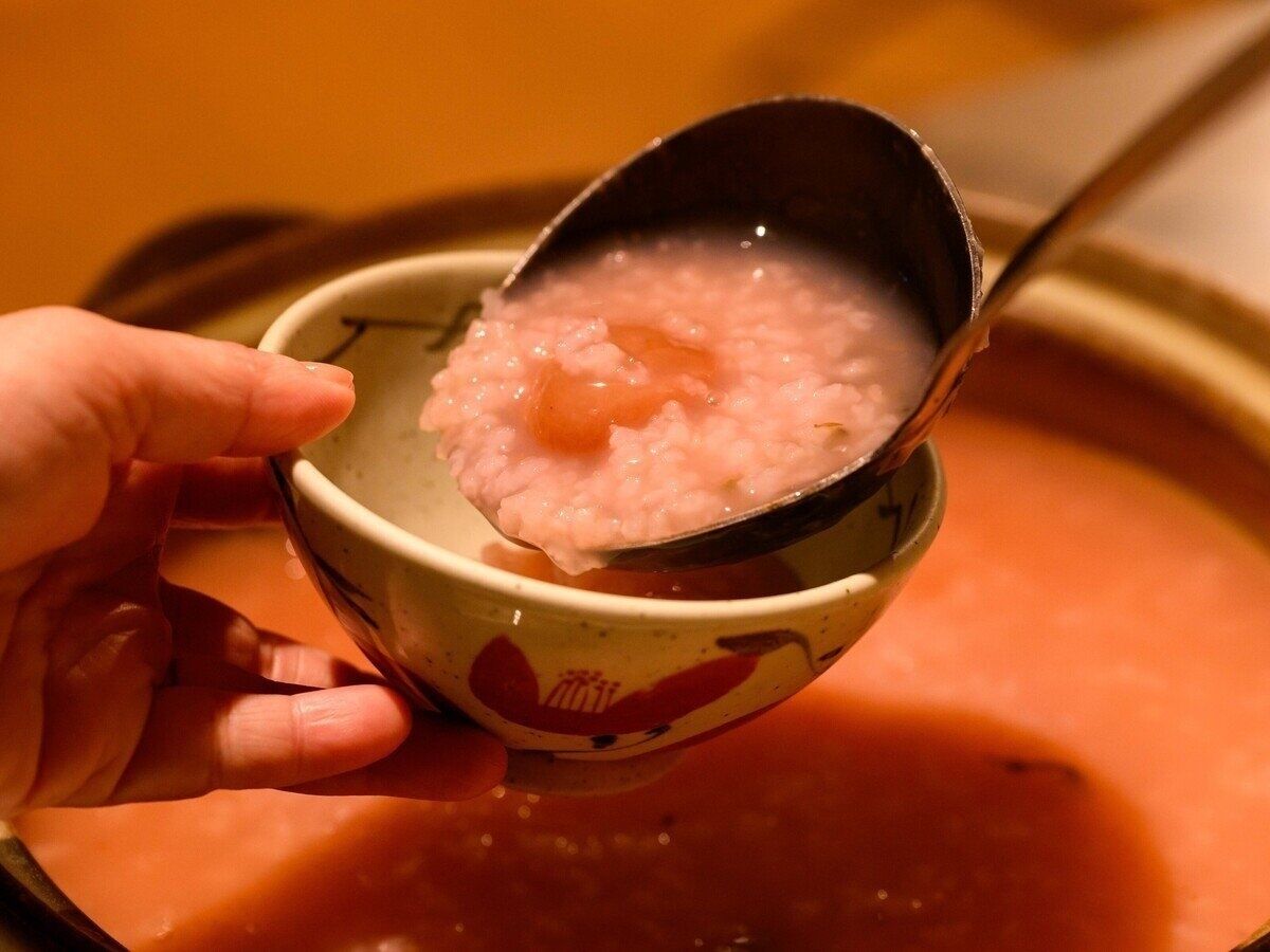 A bowl of pink rice porridge with a spoon.