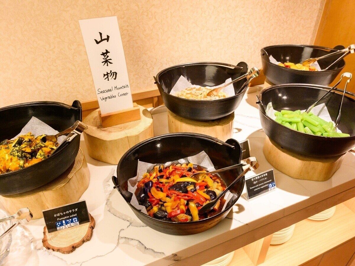 A buffet with various dishes, including a pumpkin salad and a vegetable stir-fry.