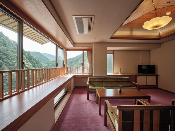 A room with a large window, a sofa, a table, and a TV. - Sansuikan Kawayu Midoriya (Tanabe)
