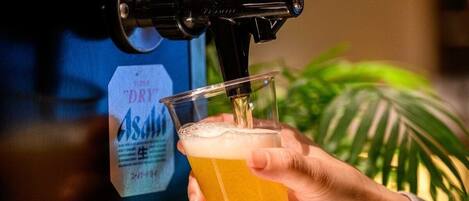 A hand holding a glass receiving beer from a tap.