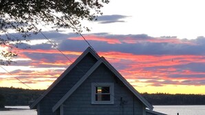 Ein zweistöckiges Haus mit Satteldach, gelegen am See.