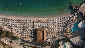 An aerial view of a beach resort with a large pool, numerous umbrellas, and a central building. - Folie Marine Beach Hotel & Club (Himare)