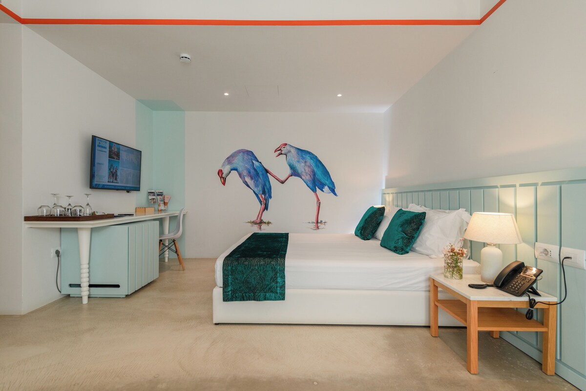 A modern bedroom with a bed, bedside table, and a small desk area.