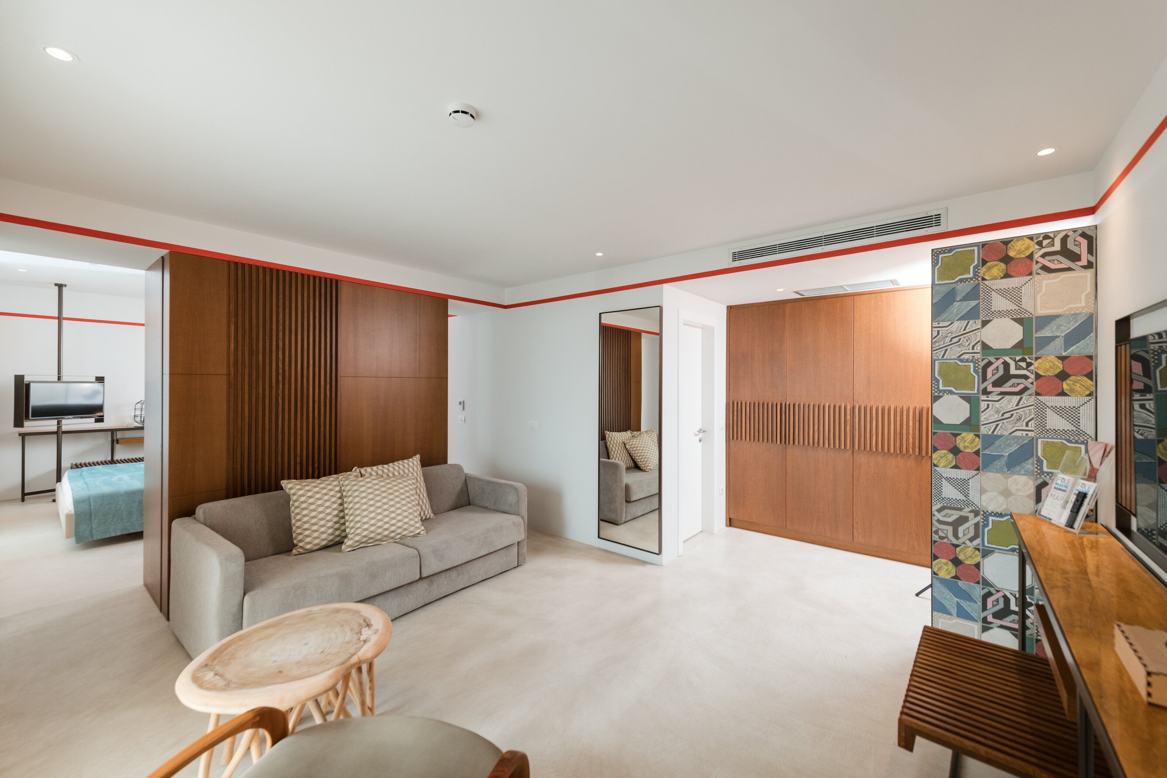 Una sala moderna con un sofá, una mesa de centro de madera y un televisor.