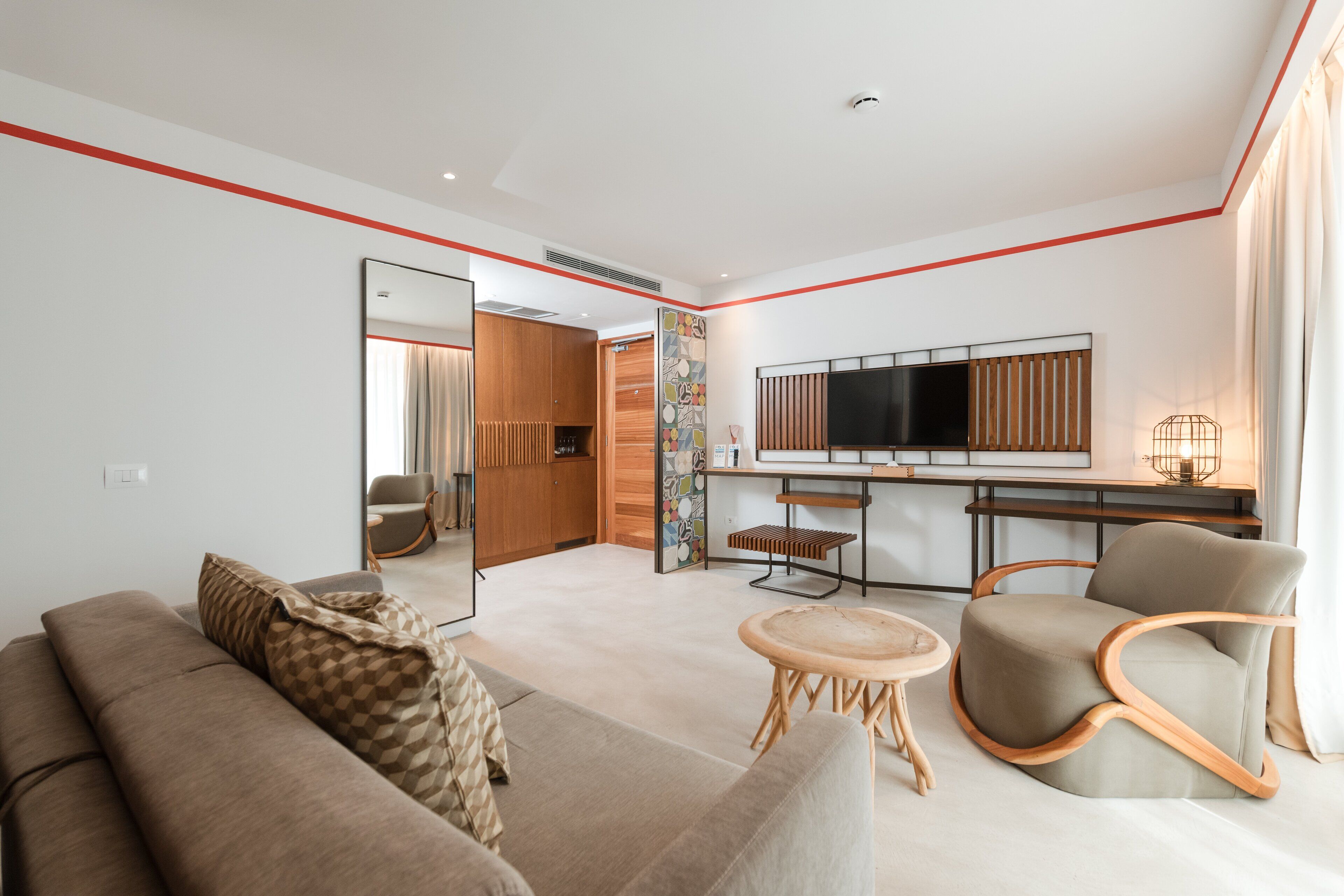 Una sala moderna con un sofá, un sillón y una mesita redonda.