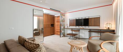 Una sala moderna con un sofá, un sillón y una mesita redonda.