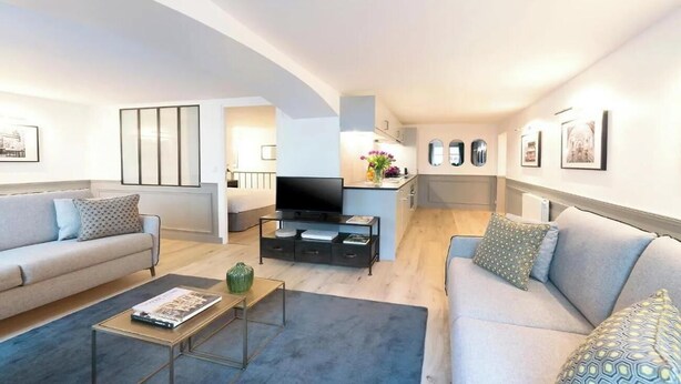 Een moderne woonkamer met een bank, salontafel en een flatscreen televisie.