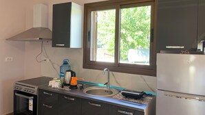A kitchen with a stove, oven, sink, and window.