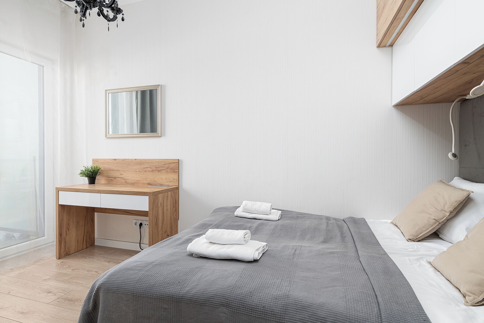 Ein modernes Schlafzimmer mit Bett, Nachttisch und Schreibtisch.