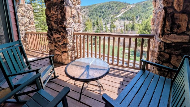 A wooden deck with a glass table and chairs, overlooking a mountainous landscape. - Summer Fun+ Mountain & River Views, Bike Path (Keystone)