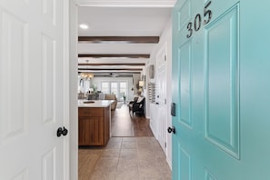 A hallway with a kitchen area, a dining table, and a door labeled '305'.
