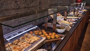 A buffet with various food items, including pastries and salads, displayed in glass cases.