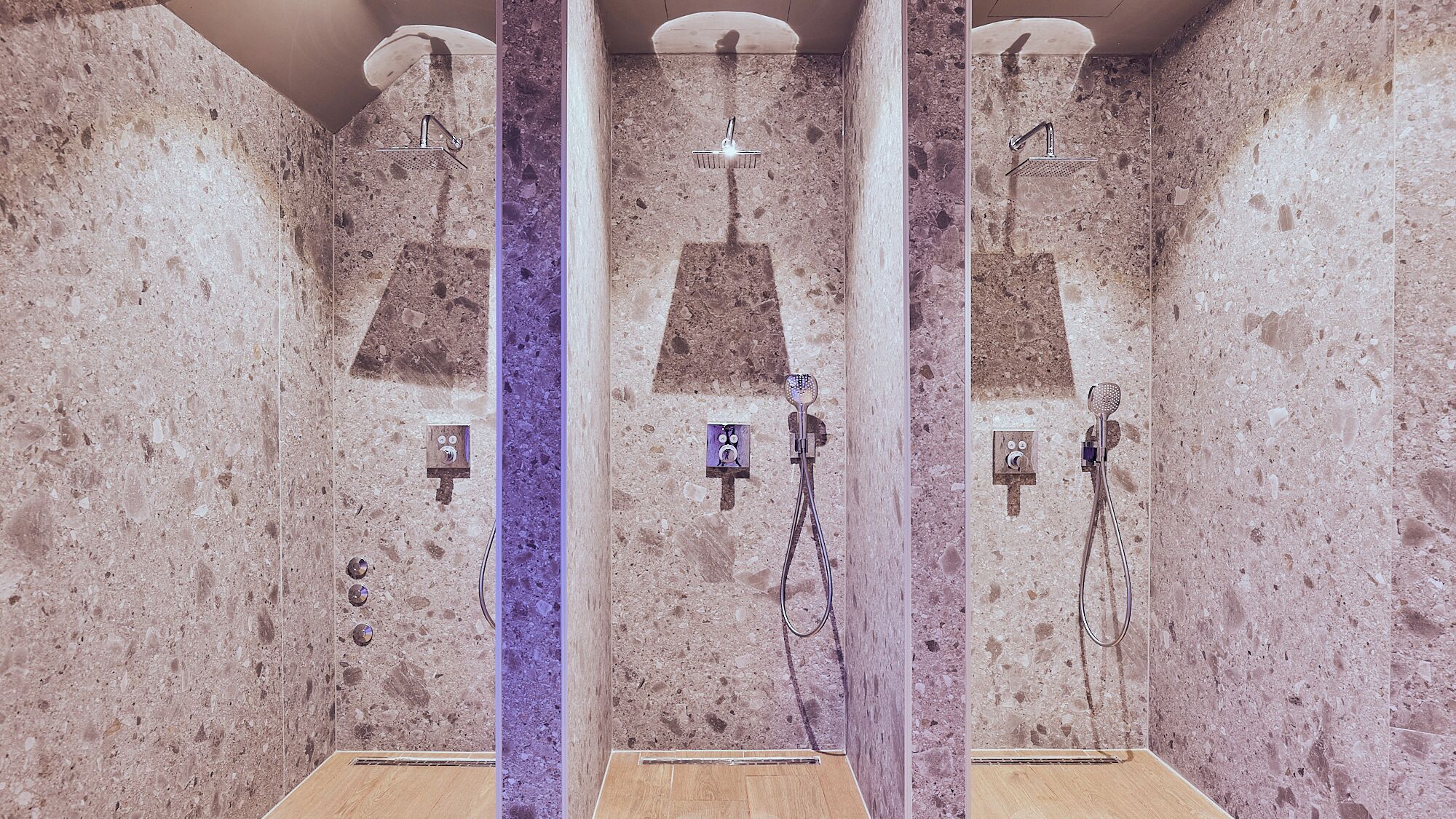 A spa with three separate shower areas, each with a handheld showerhead and a control panel.