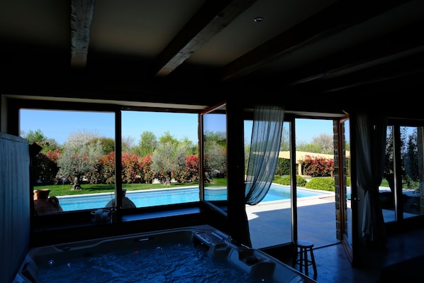 A room with a large window overlooking a swimming pool and garden. - 5 Star Luxurious Villa Paradiso d'Istria with Spa and pool (Kucibreg)