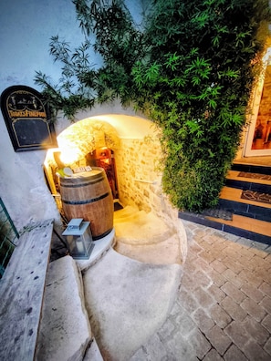 A stone-walled wine cellar with a wooden barrel, a lantern, and a sign reading "Today's Fine Food".