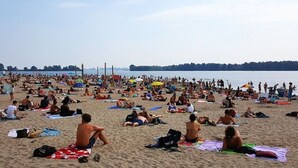 A crowded beach with people sunbathing and swimming. - A minute to the tram, a minute to the beach-explore Amsterdam like never before (Amsterdam)