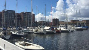 A marina with multiple sailboats docked, surrounded by modern buildings. - A minute to the tram, a minute to the beach-explore Amsterdam like never before (Amsterdam)