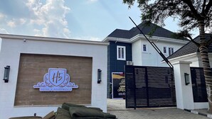 A hotel entrance with a sign for 'Hotel & Apartments' and a gated driveway.