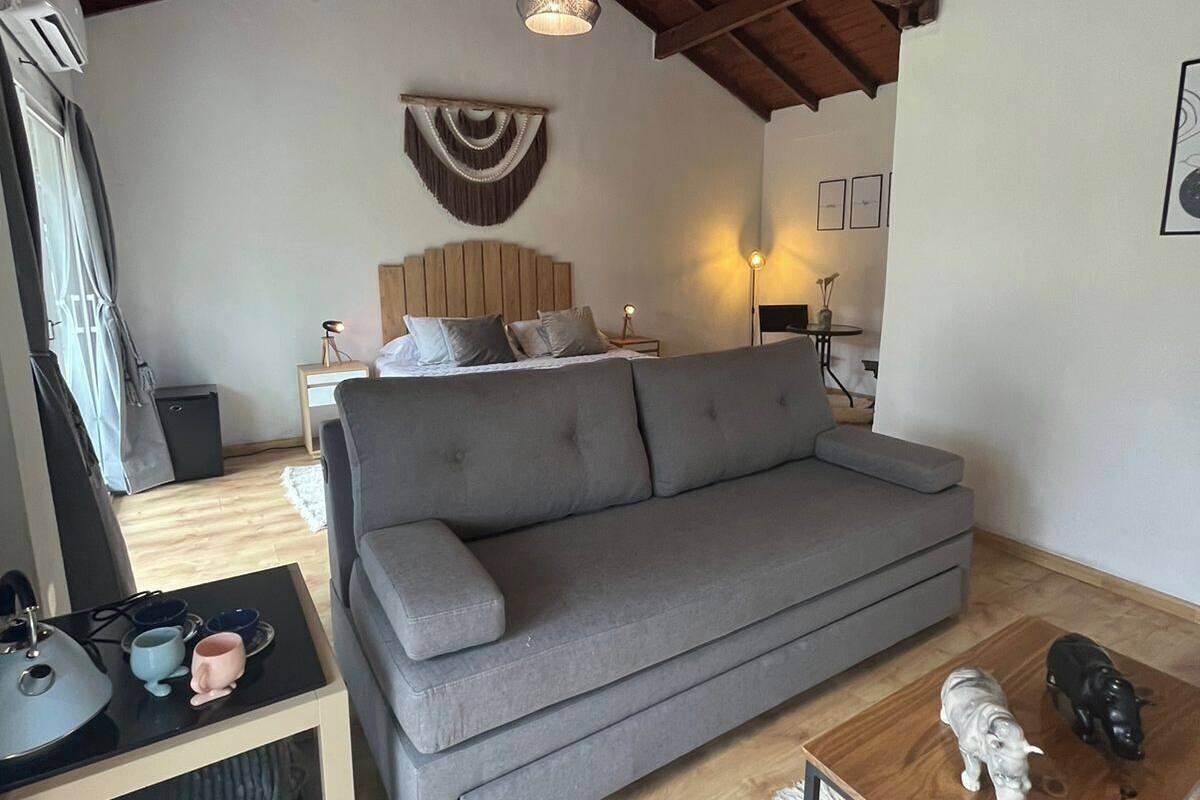 A cozy living room with a grey sofa, a wooden coffee table, and a white rug.