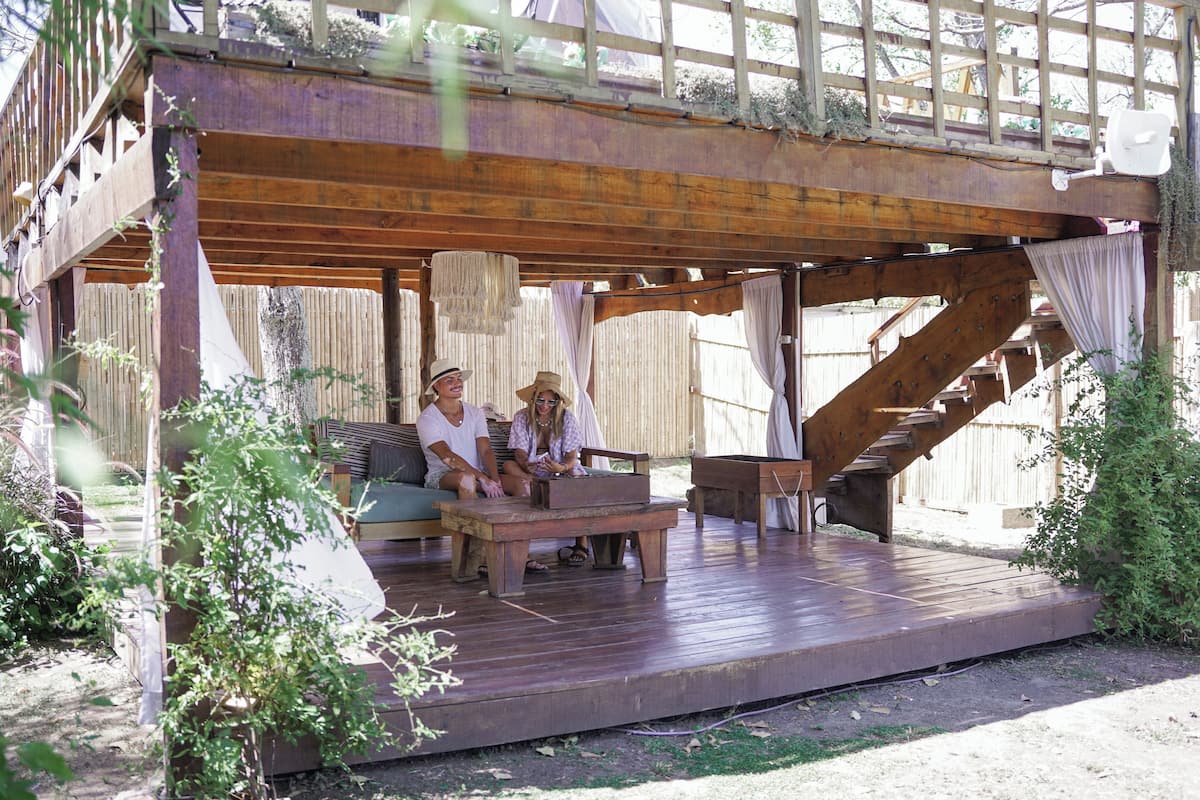 A wooden deck with a wooden staircase, a bench, and a table.