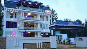 A multi-story hotel with balconies, a covered entrance, and a sign indicating 'YELAGIRLI'. - Sami Resort  (Tirupattur)