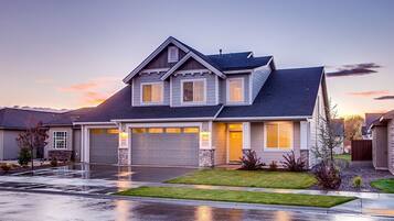 A two-story house with a garage, a well-maintained lawn, and a driveway.