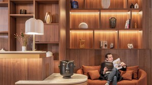 Un intérieur moderne avec un comptoir d’accueil en bois, une table ronde et un canapé.