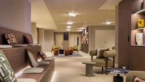 Un espace détente moderne, avec des sièges confortables, une table basse et un magazine posé sur la table.
