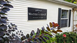 Een huis met een bord waarop staat: Welcome to The Water's Edge Michigan.