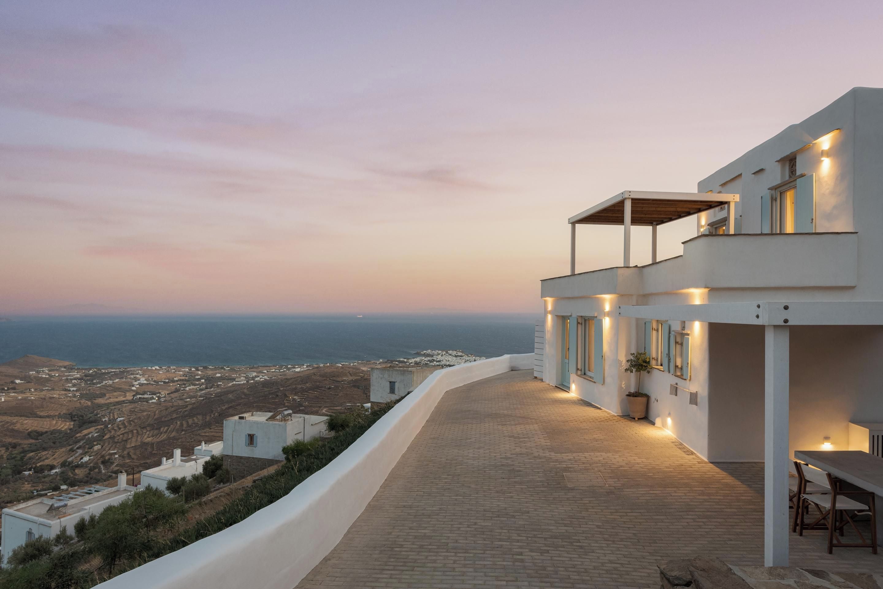 A modern building with a rooftop terrace overlooking a coastal landscape.