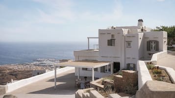 Un edificio moderno blanco con un patio que ofrece vistas a un paisaje costero.