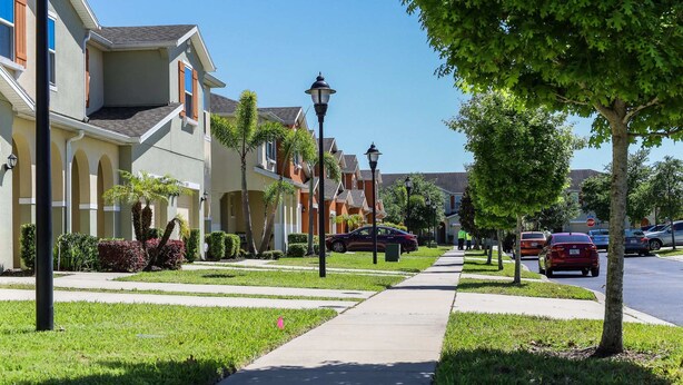 Una calle residencial con casas, aceras y automóviles estacionados.