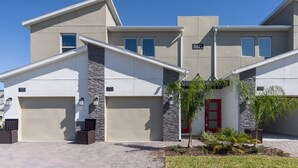 Un edificio residencial moderno con fachada de piedra, números de unidad y una puerta roja.