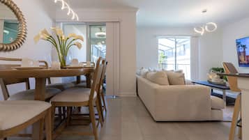 Un espacio moderno de estar con comedor, sofá y televisor.