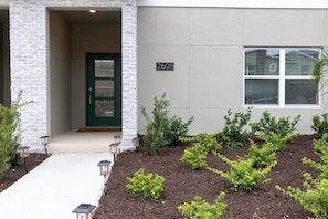 A building with a brick facade, a green door, and a number '2608' on the wall. - Amazing House Near the Parks (Kissimmee)