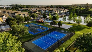 A residential area with multiple tennis courts, a playground, and a lake. - Apartment Minutes From Disney (Kissimmee)