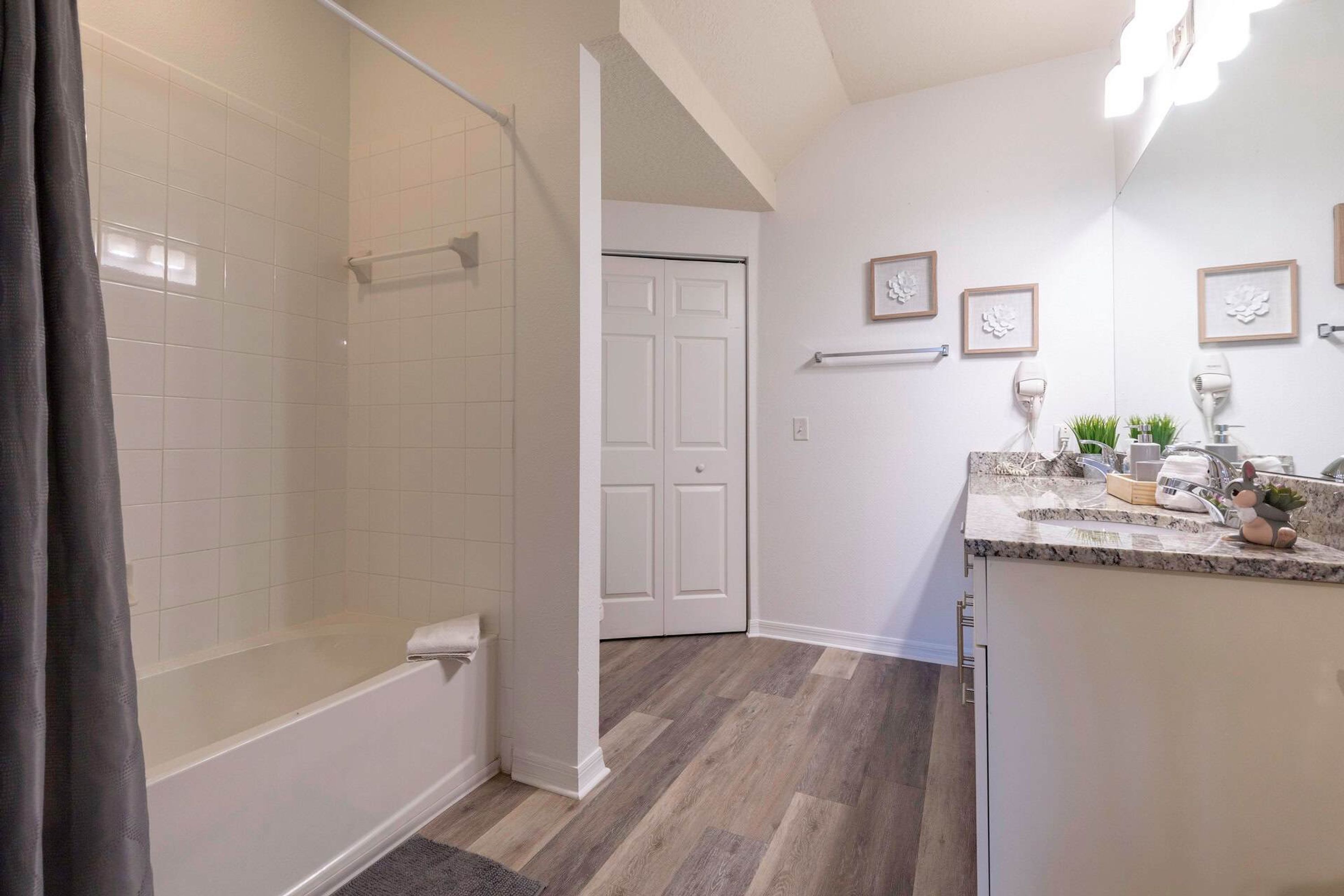 A bathroom with a shower, toilet, and sink.
