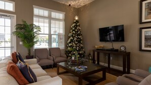A living room with a Christmas tree, a flat-screen TV, and a sofa. - Fabulous Townhome Near the Parks (Kissimmee)