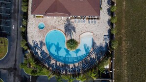 An aerial view of a resort with a large pool, sun loungers, and a covered pavilion. - Fabulous Townhome Near the Parks (Kissimmee)
