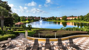 Un patio con una fuente, asientos al aire libre y vistas a un lago.