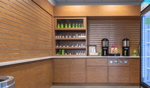 Una cocina moderna con armarios de madera, una estación de café y un dispensador de bebidas con puerta de cristal.