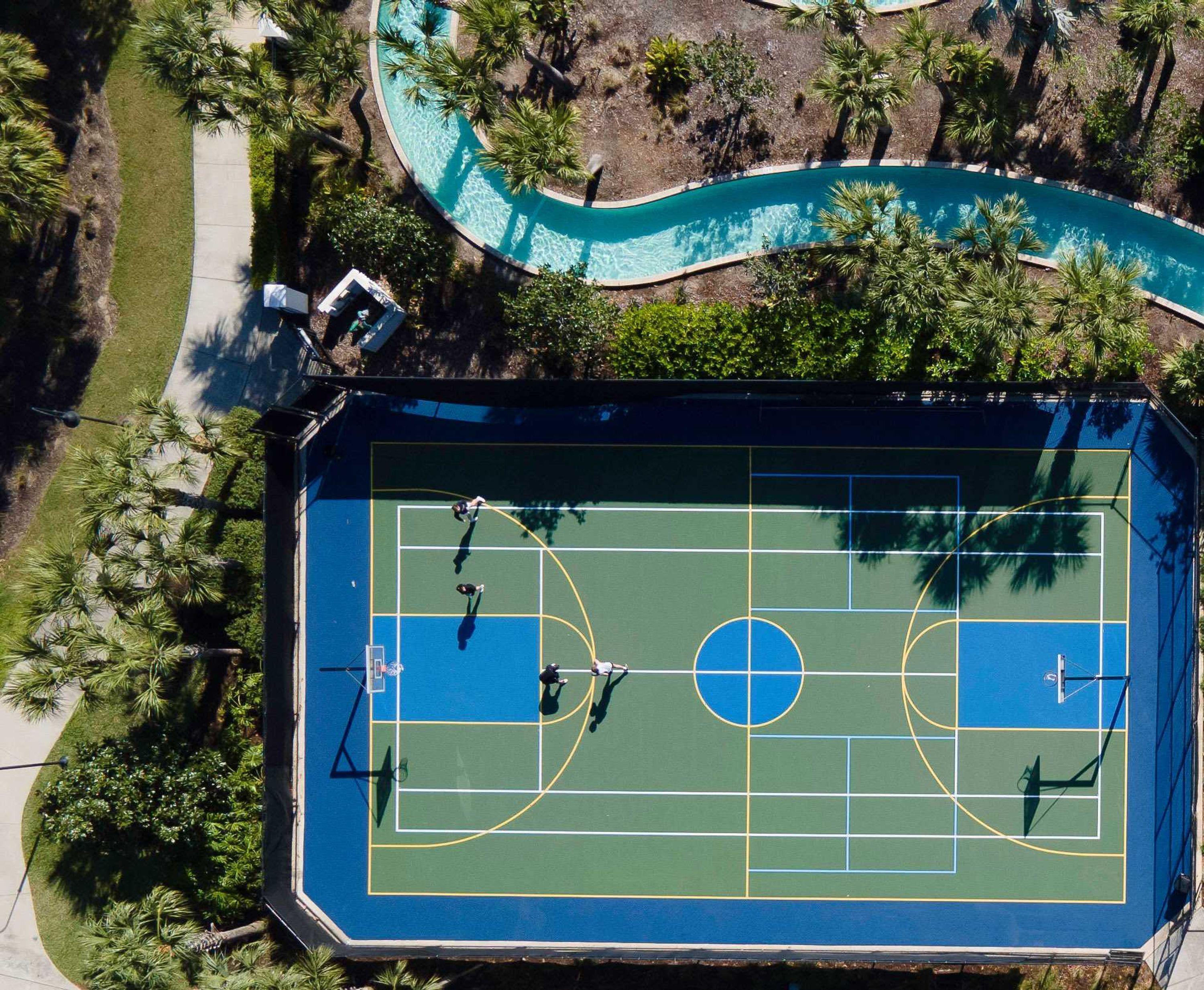Vue aérienne d’un terrain de sport avec une piscine et de la végétation environnante.