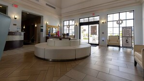 A spacious lobby with a central seating area, large windows, and an exit sign. - Fabulous Townhouse Near to Disney (Kissimmee)