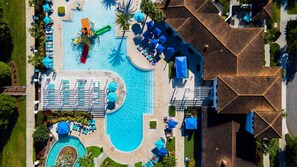 Ein Luftbild zeigt ein Resort mit einem großen zentralen Pool, mehreren kleineren Pools sowie zahlreichen Liegestühlen und Sonnenschirmen.