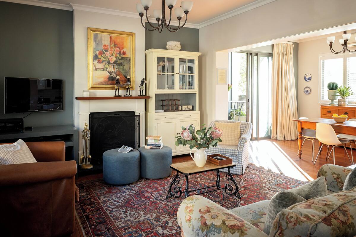 A living room with a fireplace, a television, and a dining area with a table and chairs.