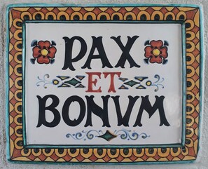 A decorative tile with the text "PAX ET BONVM" surrounded by a colorful border. - De Waterkant Guest Suites (Cape Town)