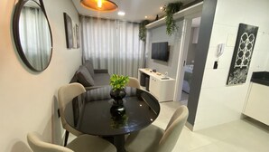 Un espace repas moderne avec une table ronde, des chaises et une plante en pot.