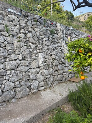A stone wall with a sign that reads 'SHOWER' and a metal structure above it. - Casa Famuli by Wonder Tour (Amalfi)