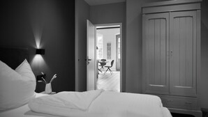 A bedroom with a bed, bedside table, and a wardrobe. - Gutshaus Suite #2 "magdalena" im Weingut Fitz-ritter - Vdp/biozertifiziert (Bad Dürkheim)