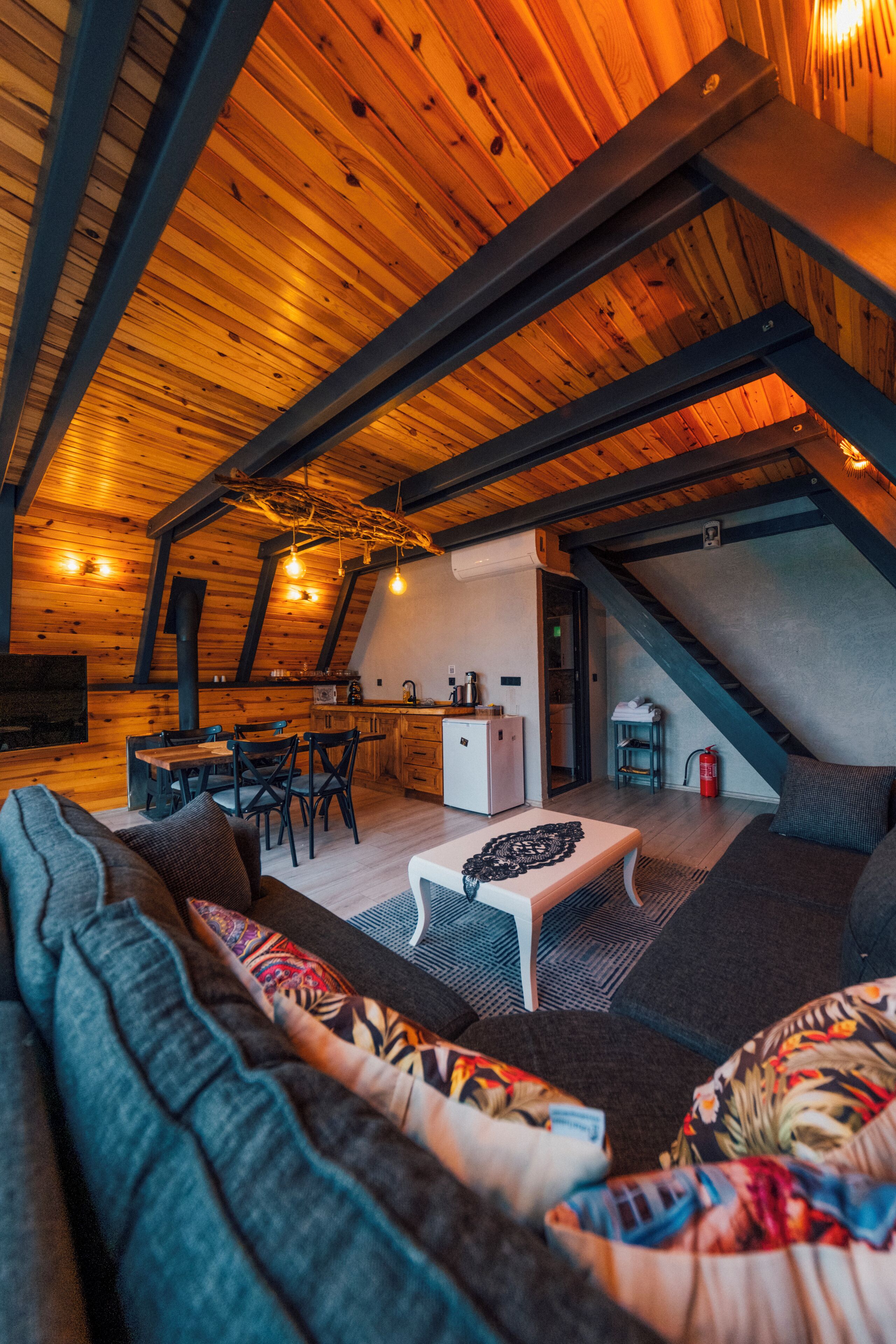 A cozy attic space with a dining area, kitchen, and seating area.